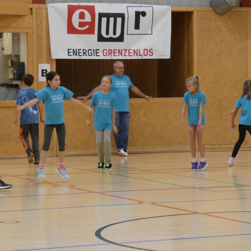 die 4. Klasseauf dem Spielfeld, im Hintergrund der Lehrer