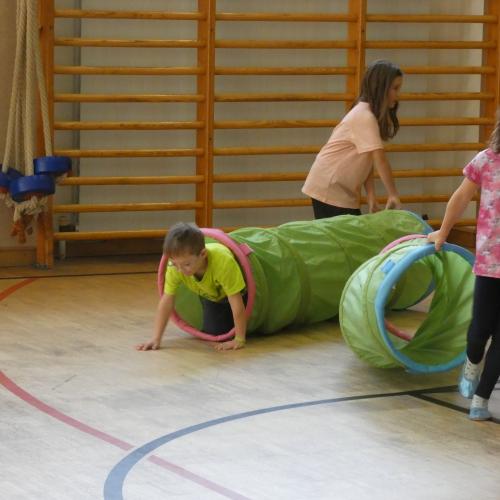 Turnsaal - 2 Kinder mit einem Kriechtunnel als Schlangenbauch