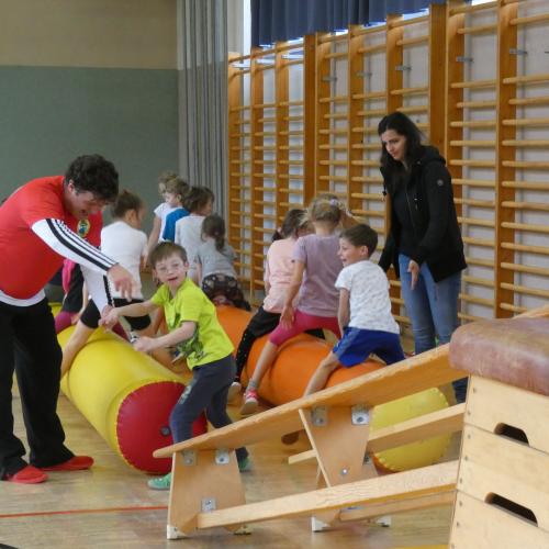 Kinder hüpfen mit Unterstützung von LehrerInnen auf den Luftwürsten