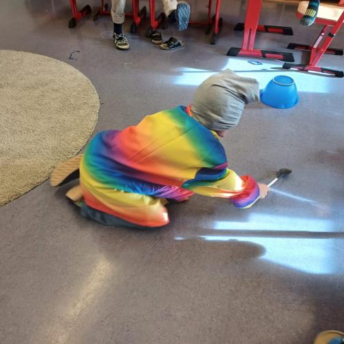 Verkleidetes Kind kriecht am Boden - beim Spiel Topfklopfen