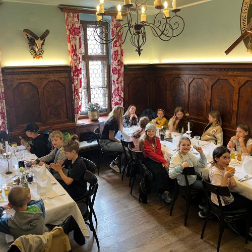 Essen in getäfeltem Saal an zwei langen Tischen, schön gedeckt