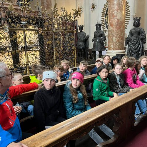 Kindergruppe sitzt in der Schwarzmanderkirche vor dem Grabmahl