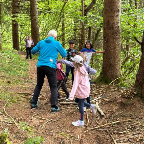 Naturpädagoge spielt mit den Kindern im Wald