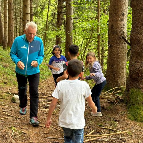 Naturpädagoge beim Spielen mit den Kindern im Wald