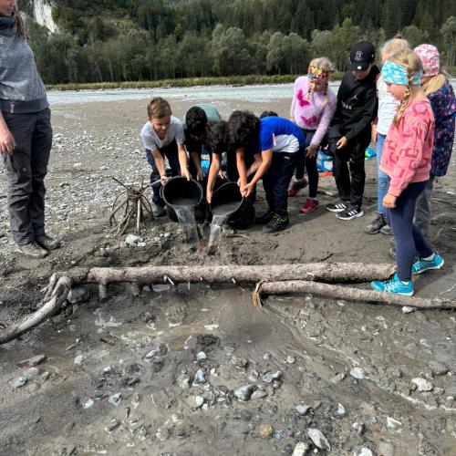 Eine Kindergruppe präsentiert ihren "Nachbau eines Wildflusses"