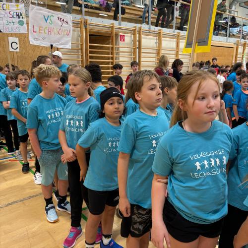 ca 7 Kinder in blauen Schul T-Shirts beim Einzug in die Sporthalle Reutte zum Völkerballturnier