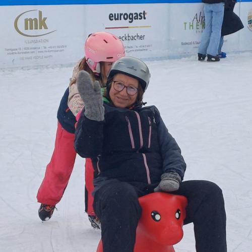 ein Mädchen schiet die Lehrerin, die auf einem roten Schiebehund sitzt