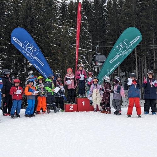 SIegerehrung - alle Kinder einer Gruppe stehen um das Siegepodest  mit zwei Fahnen