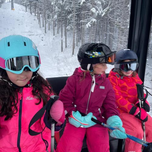 Drei Mädhen sitzen in der Gondel im Schigebiet Berwang