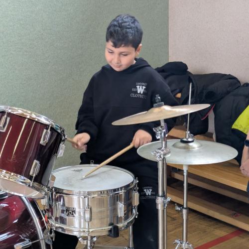 Ein Junge versucht sich am Schlagzeug