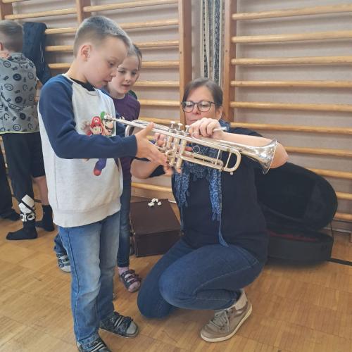 Ein Mitglied der MK erklärt einem Jungen das Tenorhorn