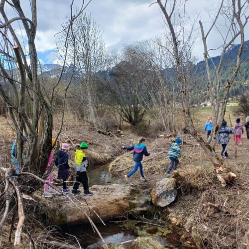 Eine Gruppe Kinder beim Überqueren eines kleinen Baches