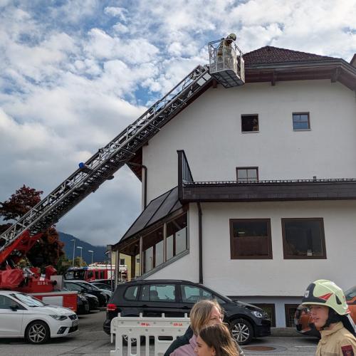 MAn sieht die Drehleiter des Feuerwehrautos, das sich in Richtung des Fensters im 2. Stock bewegt, von wo die SchülerInnen geborgen werden sollen.