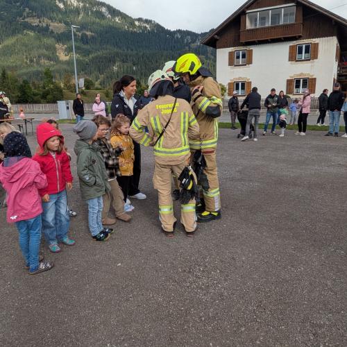 Am Sammelplatz befragt ein Feuerwehrmann eine Lehrerin, um zu überprüfen, o alle Kinder das Schulgebäude verlassen haben.