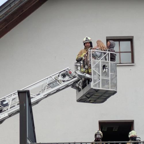 Der Bergekorb der Drehleiter wieder auf dem Weg Richtung Boden Im Korb ein Feuerwehrmann und zwei Kinder