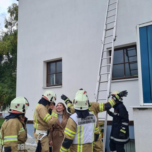 EInige Feuerwehrmänner stellen die LEiter auf zu einem Fenster im 1. Stock