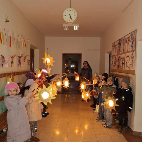 Am Gang im Schulhaus stehen die Kinder der 1: Klasse mit ihren Laternen, in denen bereits das Licht brennt.
