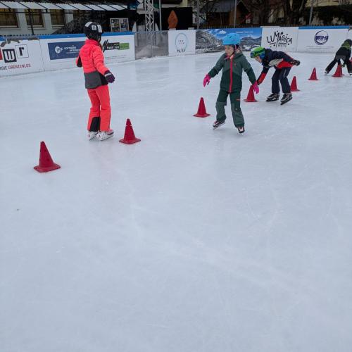 Einige Kinder fahren um Pylonen Slalom