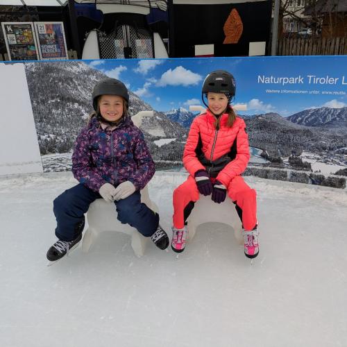 2 Kinder sitzen auf den "Eisbären" vor dem Hintergrund der Werbetafel für den Naturpark Lech