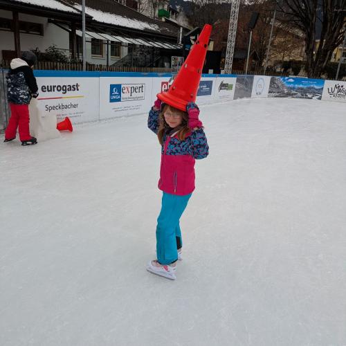 Ein Kind hat eine große rote Pylone als Hut auf