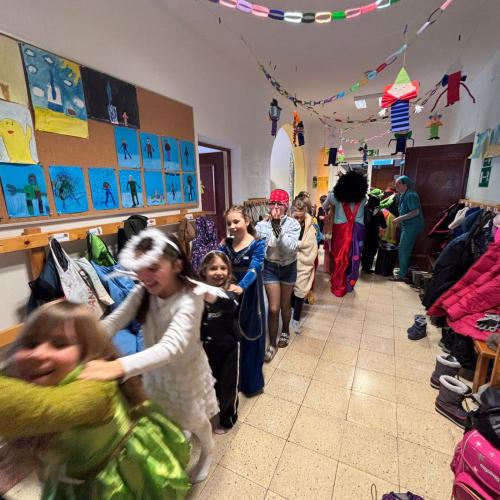 Polonaise durchs Schulhaus - die Kinder gehen als Schlange zu Polonaisemusikdurch den Gang 