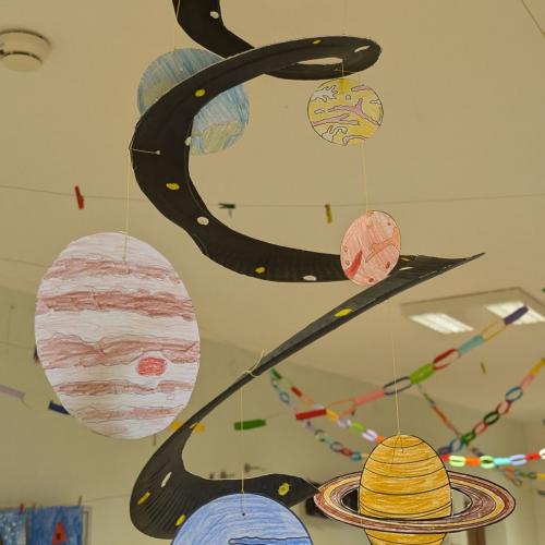 Ein Mobile unseres Sonnensystems mit allen Planeten hängt von der Decke im Gang