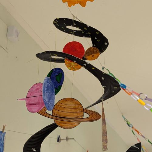 ein Mobile aus einem Pappteller mit Sonne und allen Planeten, das die Kinder gebastelt haben