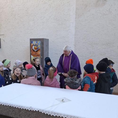 Die Erstkommunionkinder stehen mit Dekan Franz Neuner rund um den ALtat