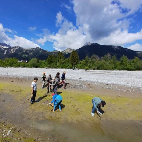 Kinder erkunden das riesige Bachbett des Lechs bei Lechaschau bei schönem Sonnenschein