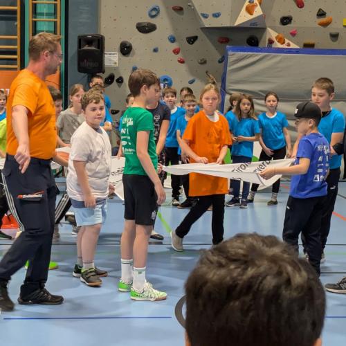 Wie bei einer Olympiade. von jeder Mannschaft ein Kind trägt an der Fahne mit, die in der Turnhalle aufgehängt wird