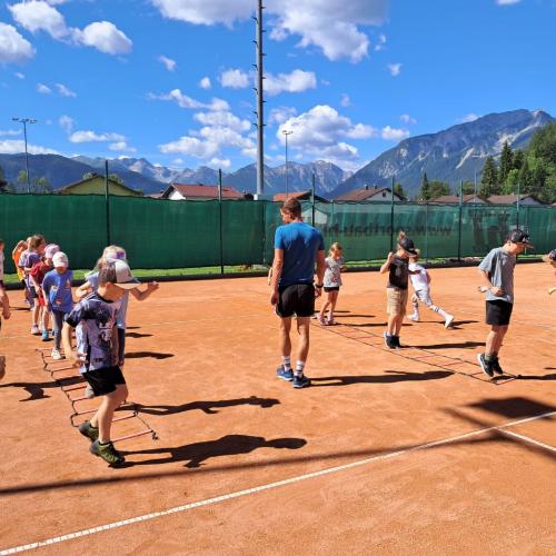 Tennisplatz Lechaschau - die Kinder bewegen sich um den Tennislehrer