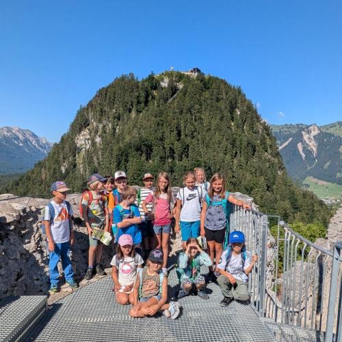 Gruppenbild der Klasse auf einer Plattform im Hintergrund der Schlosskopf unter baluem Himmel