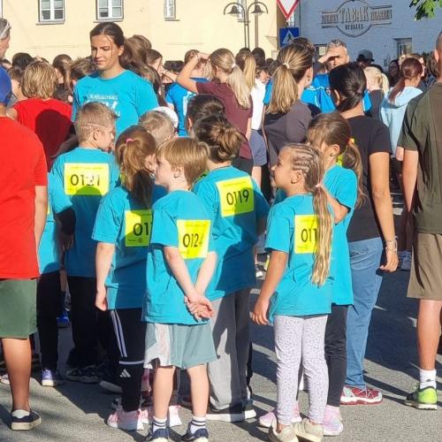 Die Kinder stehen mit den türkisen t-Shirts mit den gelben Startnummern vor dem Start zusammen