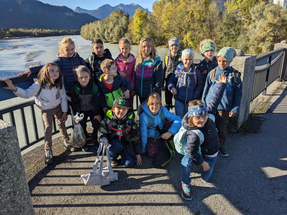 Die 14 Kinder der Klasse stehen in Lechaschau auf der Brücke im Hintergrund der Lech und Auwald