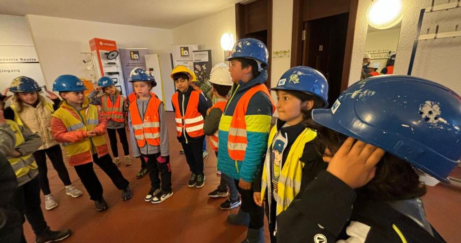 Kinder der 2. Klasse stehen im Kreis - ausgestattet mit Helm und Warnweste