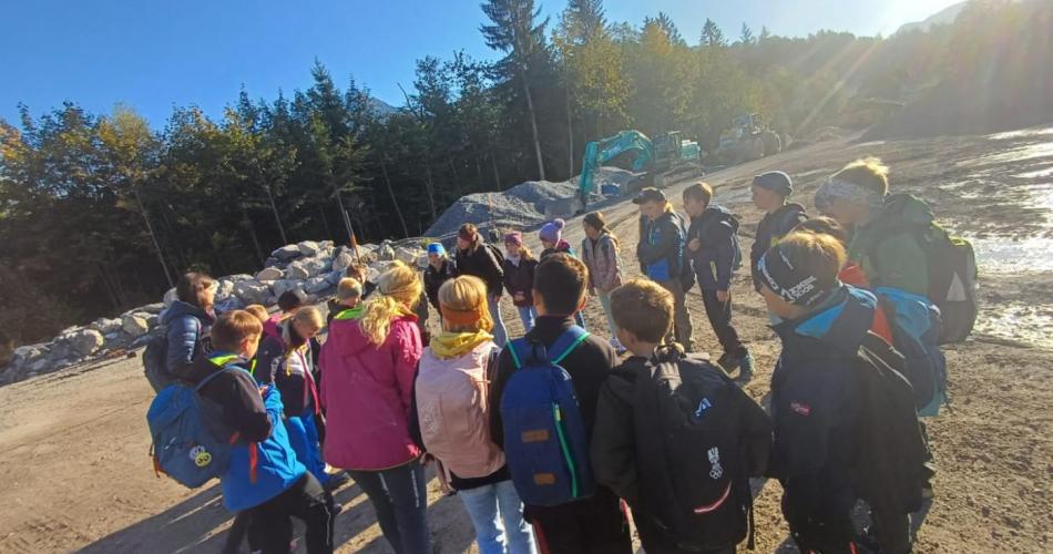 Kindergruppe im Kreis - im Hintergrund Wald und ein Bagger