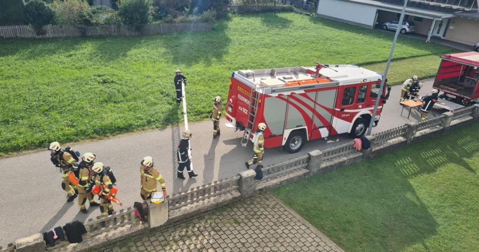 Feuerwehrauto steht vor dem Schulgebäude, eine lange Leiter wird gerade ausgeladen