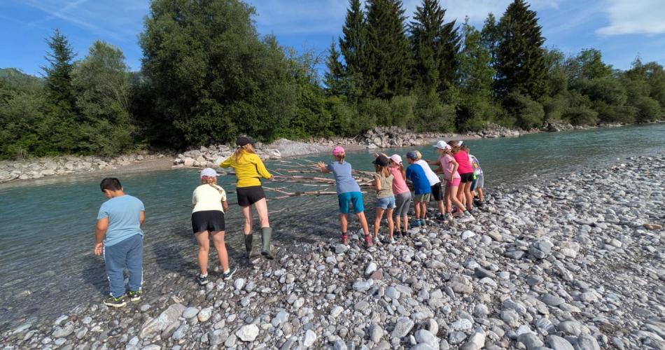 Die Kinder stehen am Ufer des Lech 
