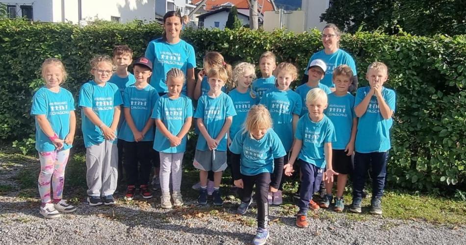 Alle Kinder der 2. Klasse stehen mit ihrer Lehrerin in den türkisen Schul - T-Shirts vor dem Start zum Rotarier Lauf in Ruette