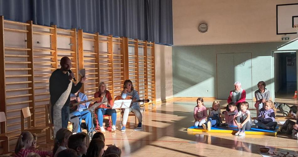 Alle Kinder der Schule stehen bzw. sitzen im Turnsaal und feiern eien Andacht